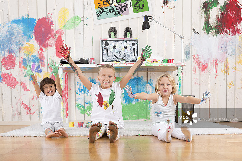 三个女孩用手指颜料粉刷办公室图片素材