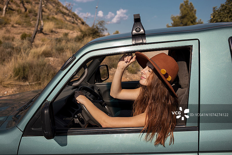 坐在车里戴帽子的年轻女人图片素材