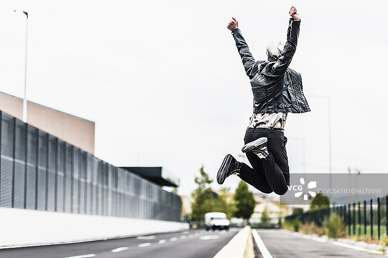 朋克风格女子在路边障碍物上跳跃图片素材