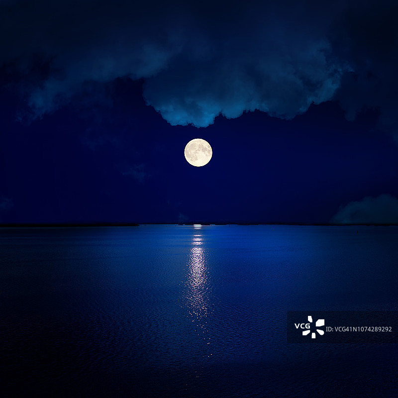 水面上云层中的满月图片素材