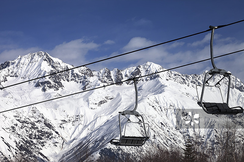 滑雪胜地的缆车和晴朗的阳光明媚的白天的雪山图片素材