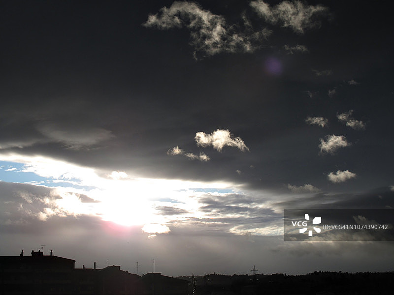 城市天际线上黑暗的天空和蓬松的白云图片素材