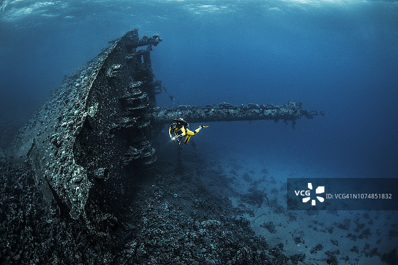 水肺潜水员在红海底部环绕探索大型沉船图片素材