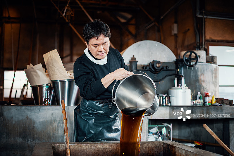正在准备染料制作手工纸的中年日本男人图片素材