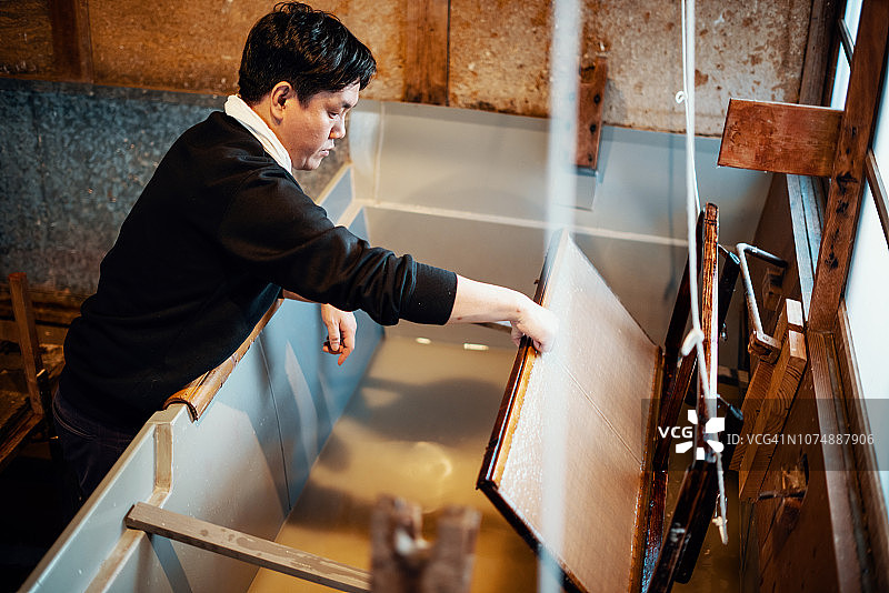 用传统方法造纸的中年日本男子图片素材