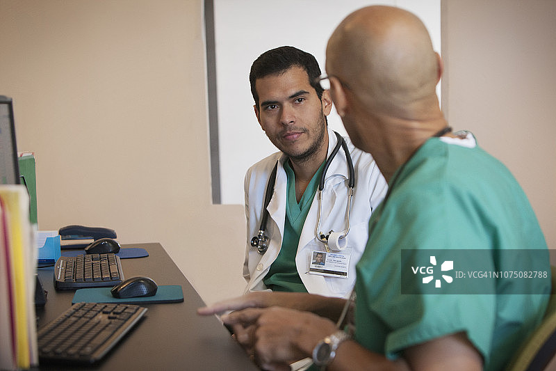 两位外科医生在办公桌前讨论图片素材