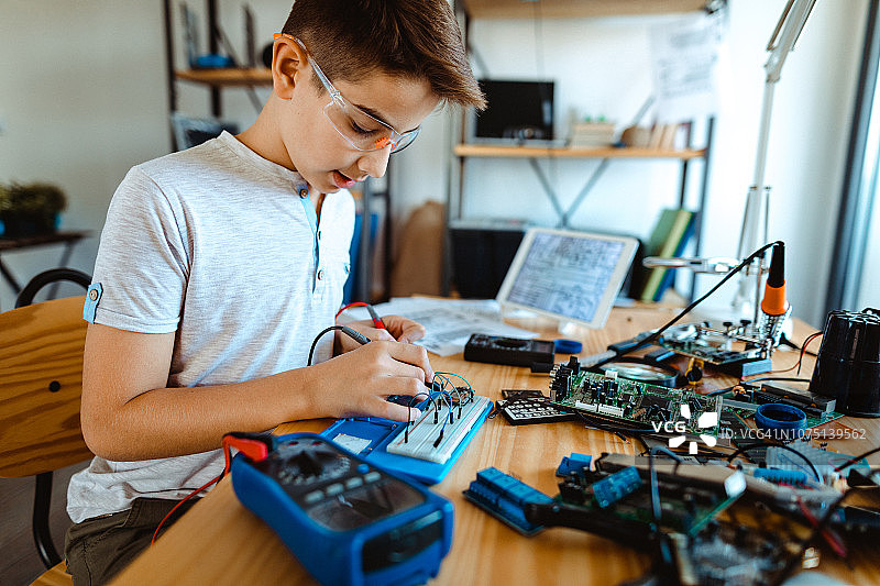 男孩用数字万用表检查电压图片素材
