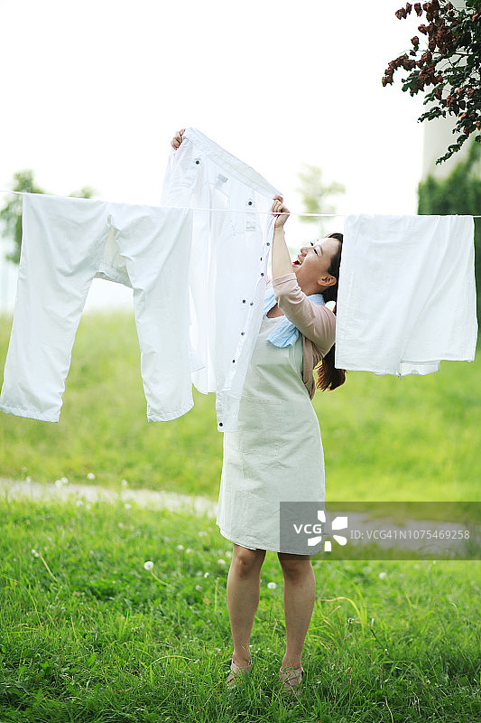 女人在晾衣绳上晾衣服图片素材