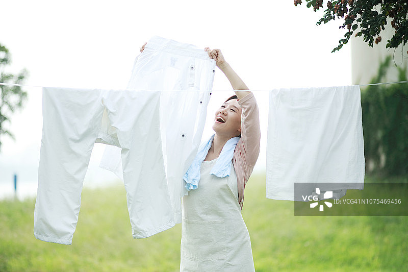 女人在晾衣绳上晾晒衣物图片素材