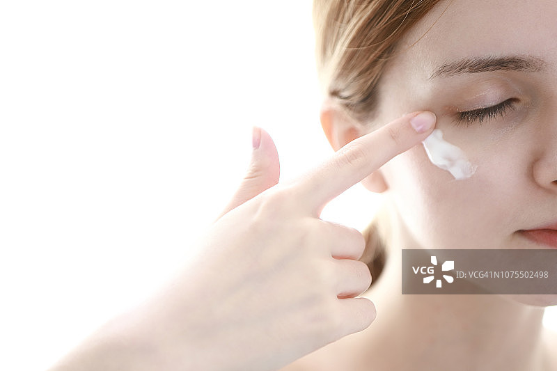 女人涂抹眼霜图片素材