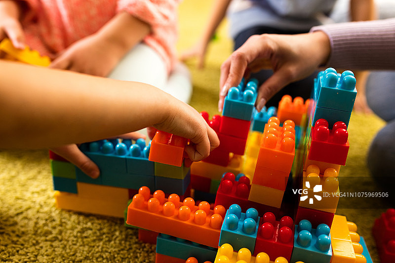 孩子们在地毯上玩积木的特写图片素材