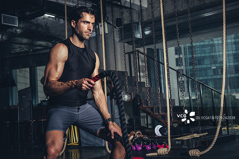 在健身房用战绳锻炼的运动员图片素材