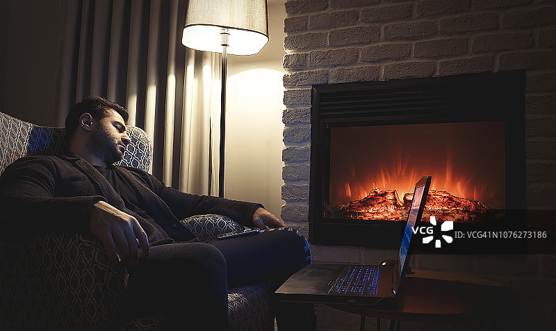 商人深夜在家壁炉旁工作睡着图片素材