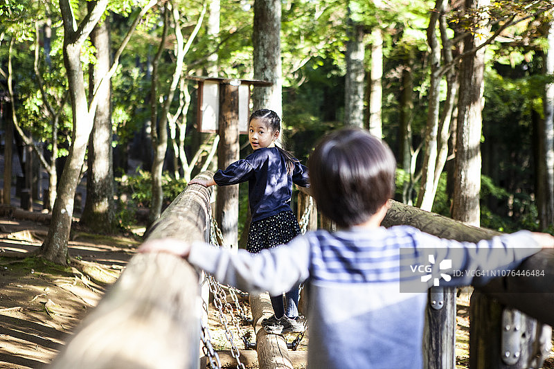 公园里木桥式游乐设备，孩子们在玩耍图片素材