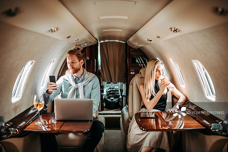 乘坐私人飞机的富有成功年轻夫妇图片素材