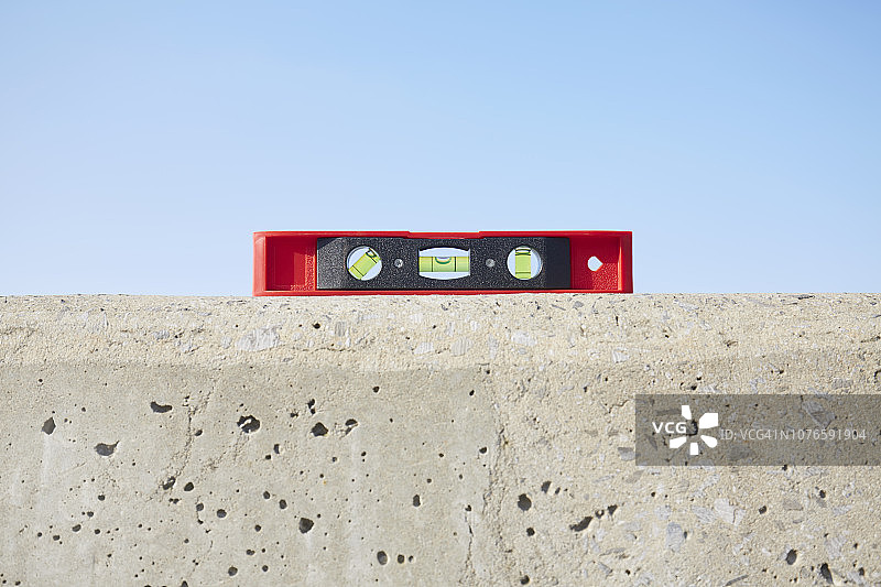 红色水平仪与混凝土墙的静物摄影图片素材