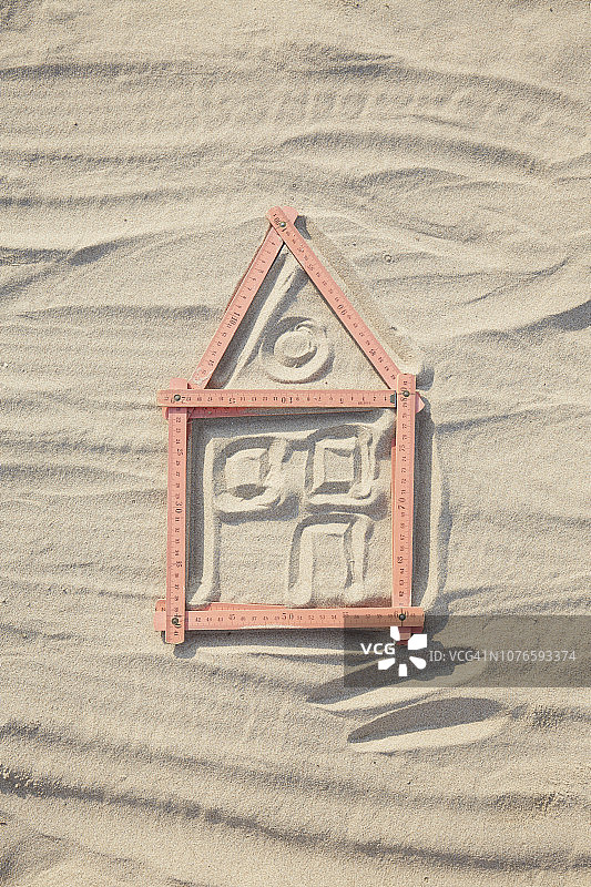 沙地/建筑工地上红色折叠尺组成的房屋形状俯视图片素材