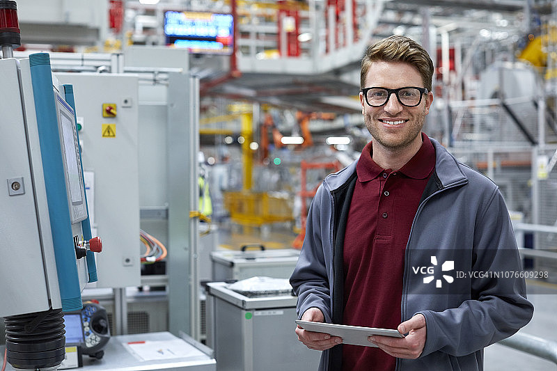 在汽车厂手持平板电脑的男工程师图片素材
