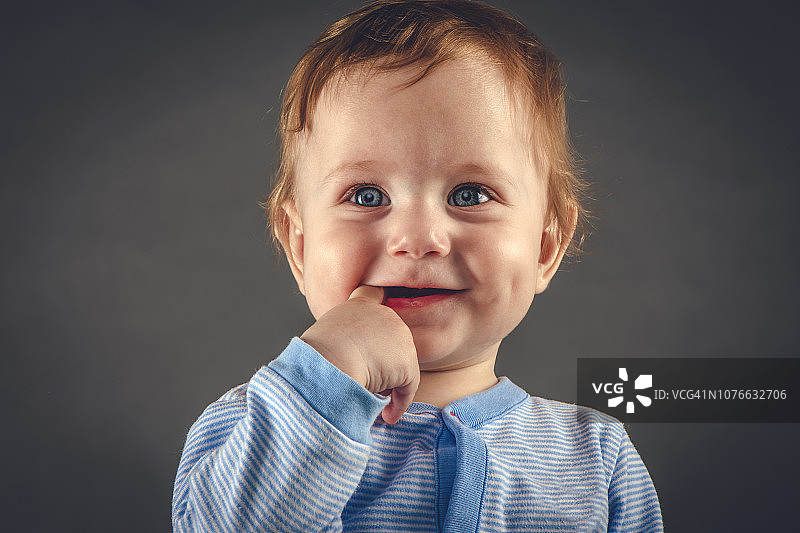 灰色背景上9个月大的男婴的写真图片素材