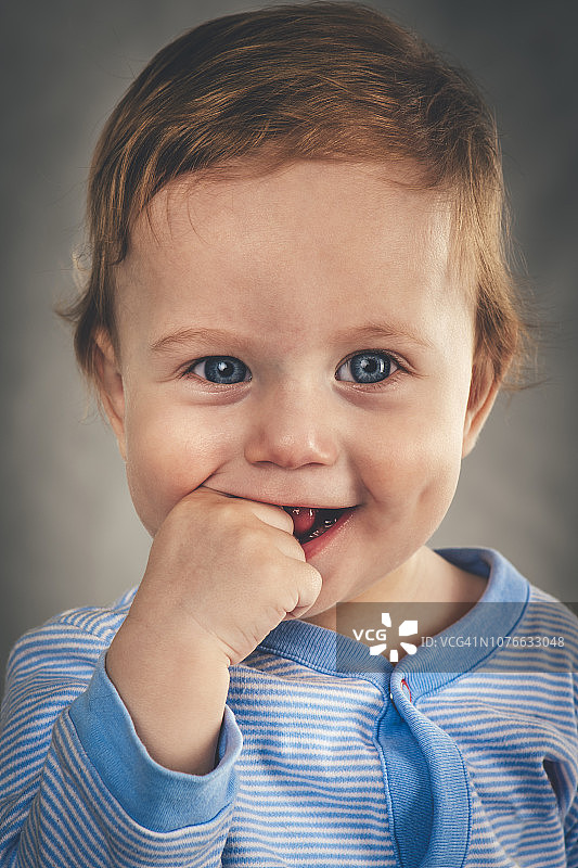 灰色背景上9个月大的男婴的写真图片素材