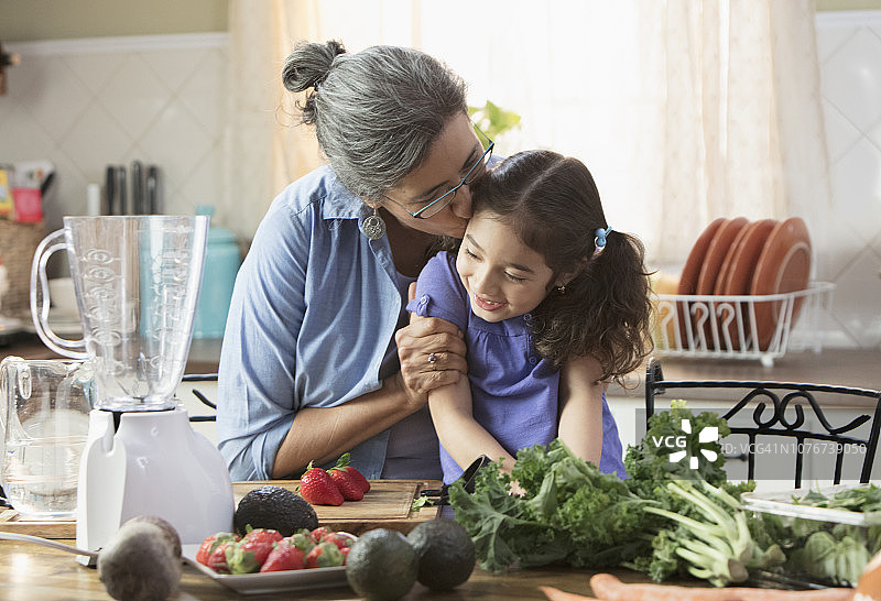 西班牙裔祖母和孙女在厨房做沙拉图片素材