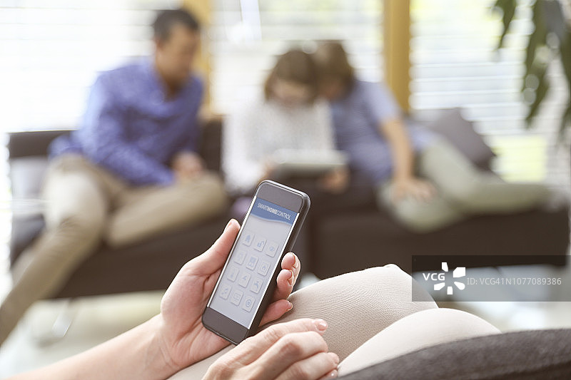 女人用手机控制智能家居图片素材