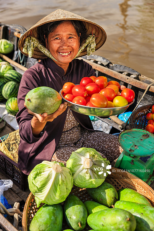 在越南湄公河三角洲水上市场卖水果的越南妇女图片素材