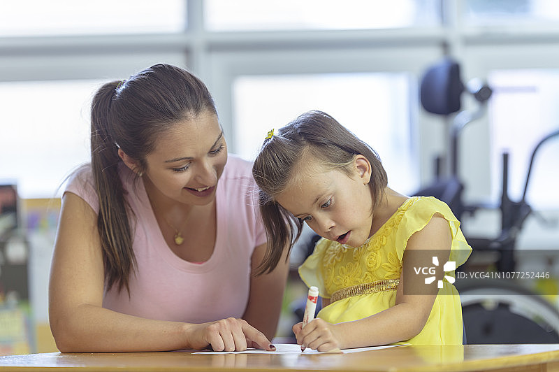 老师帮助残疾儿童绘画图片素材