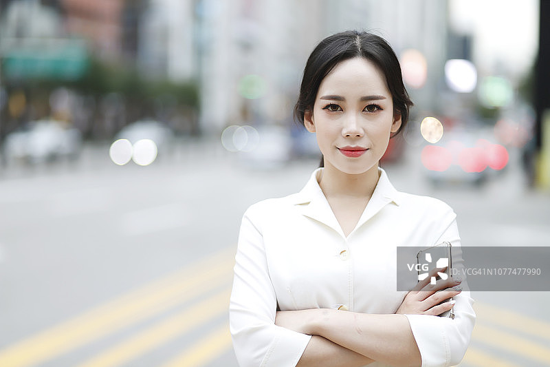 在城市街道上双臂交叉的女人图片素材