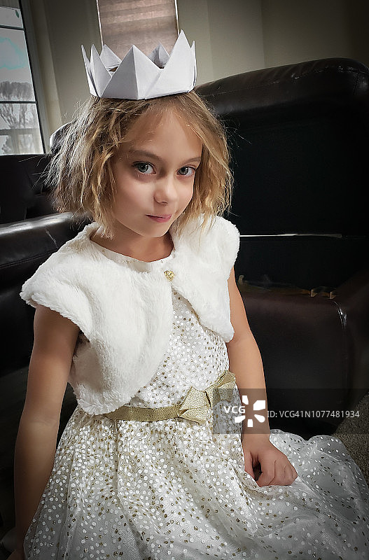 穿着漂亮的裙子，戴着纸皇冠的小女孩图片素材