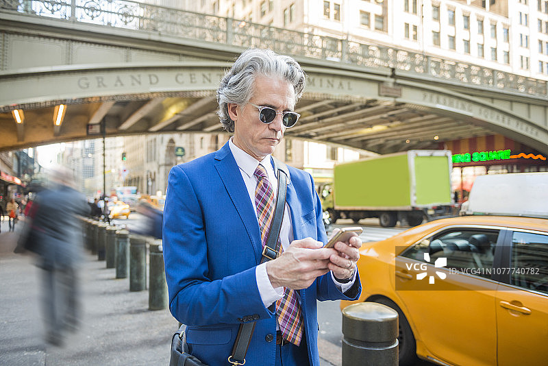 在美国纽约用手机发短信的年长美国商人图片素材