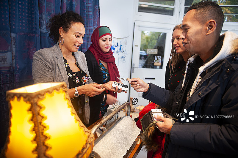 非接触式支付：顾客在创意快闪店用卡支付图片素材