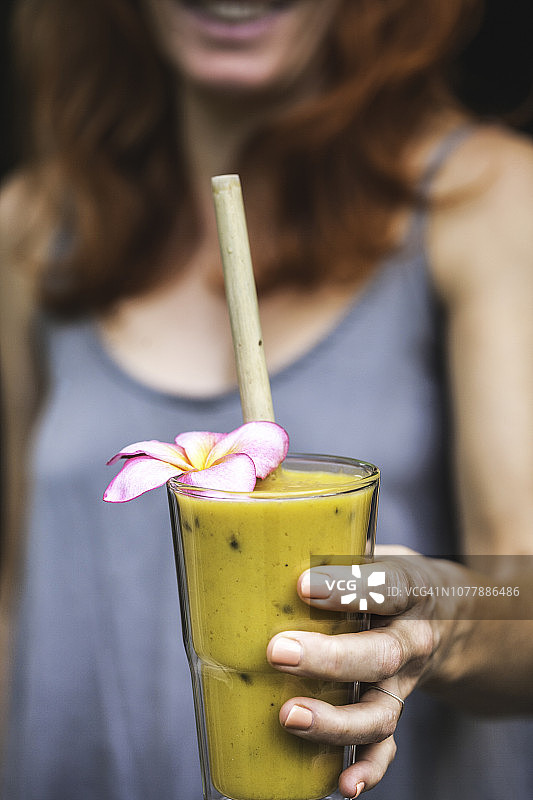 女孩手持热带百香果芒果冰沙图片素材