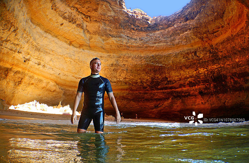 葡萄牙阿尔加维海洋洞穴下的年轻男人图片素材