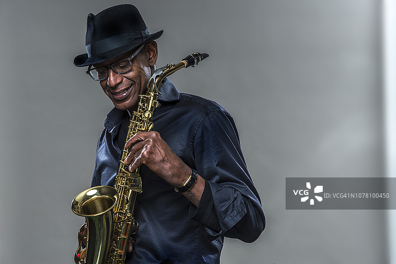 带着灿烂笑容演奏萨克斯的音乐家图片素材