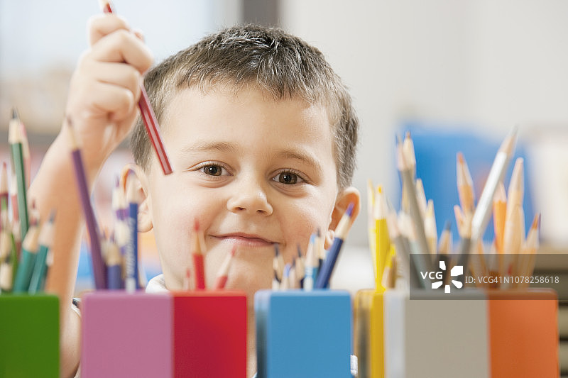 儿童在学校教室里捡起彩色铅笔图片素材