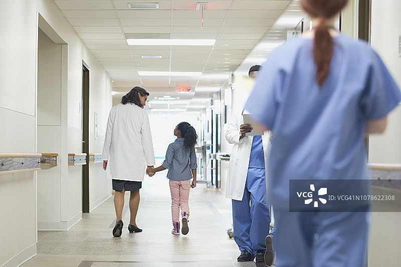 女医生在医院里和年轻女病人一起走图片素材
