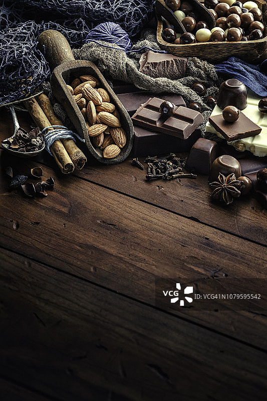 木桌上老式风格的巧克力、坚果和配料图片素材