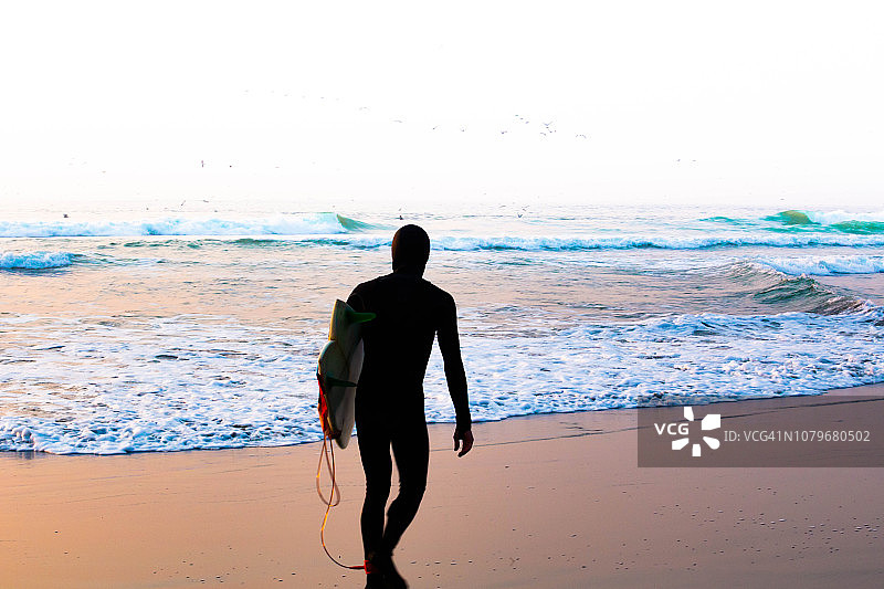 日落时分，冲浪者在旧金山海洋海滩沉思图片素材