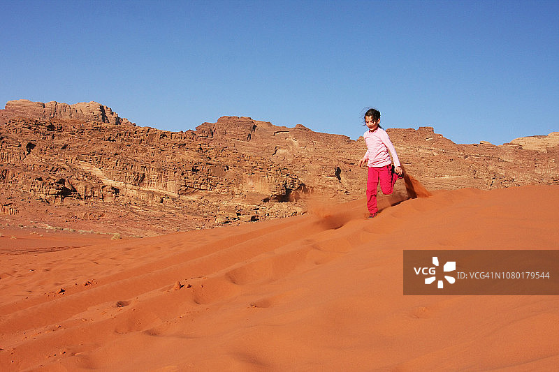 在约旦瓦迪拉姆沙漠沙丘上跳跃图片素材