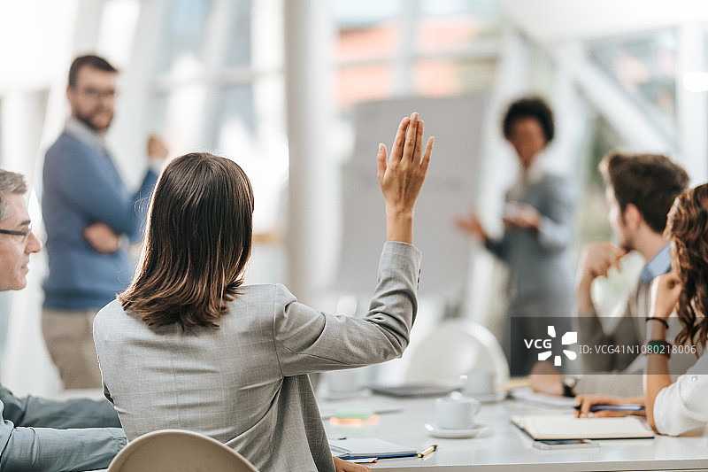 商务女士在办公室向同事提问的背影图片素材