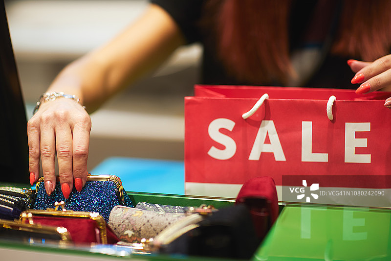 箱包配饰店里被拿起的蓝色零钱包特写图片素材