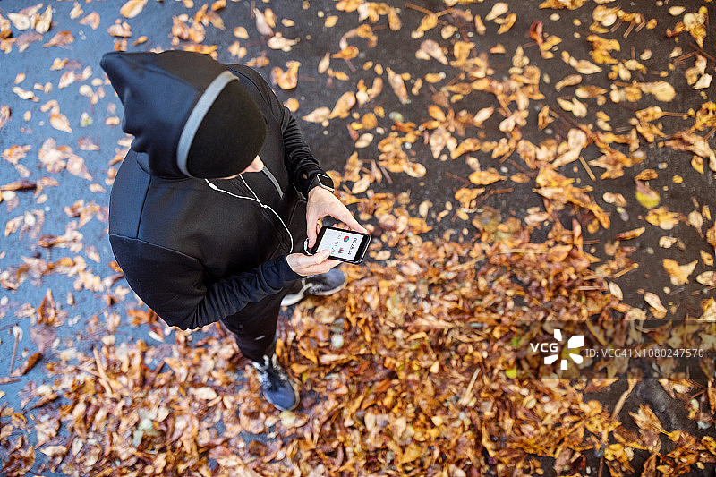 男人用智能手机查看健身数据图片素材