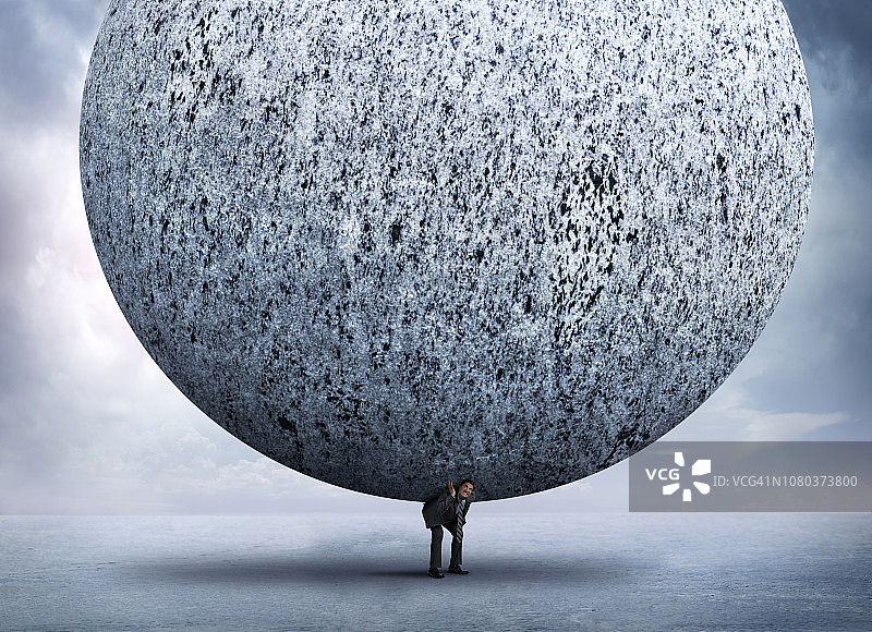 弯腰支撑背上巨大石球的商人图片素材