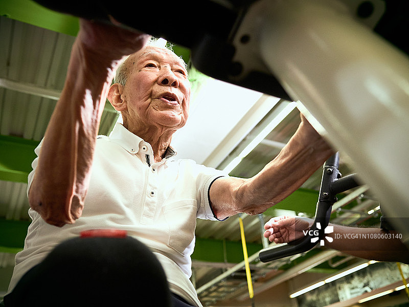 在运动俱乐部里骑自行车的年长男人图片素材