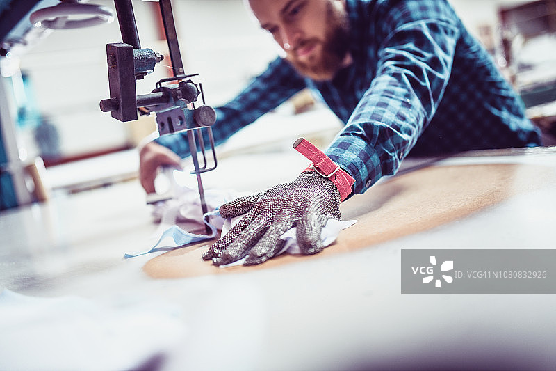 尝试新防护手套的络腮胡纺织工人图片素材