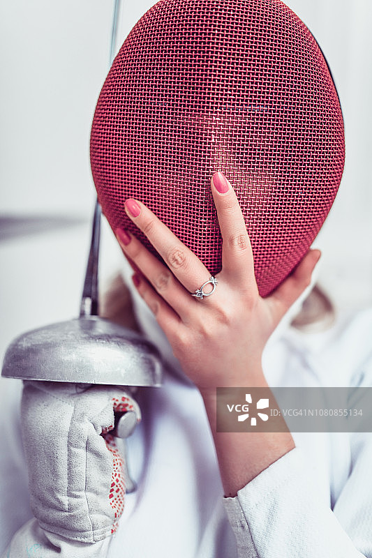 女击剑手拿着她的防护面具摆姿势图片素材