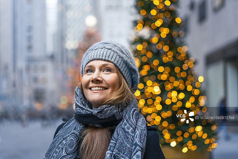 微笑的成熟女人在城市里享受圣诞节图片素材