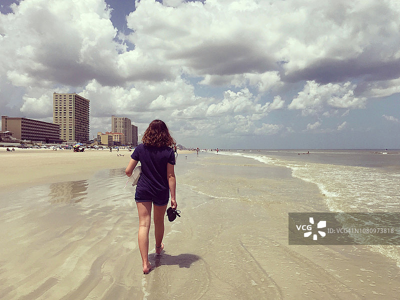 在海滩上行走的女孩背影图片素材