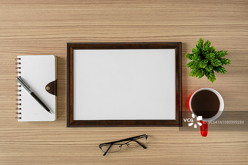 木制背景上的空木制相框、笔记本和咖啡杯图片素材